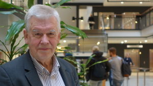Kjell Asplund var särskild utredare när Sverige senast utredde komplementär och alternativ medicin. Kjell Asplund, en äldre man med grått hår i randig skjorta och kavaj står innuti en byggnad. I bakgrunden går människor och det syns en trappa till andra våningen.