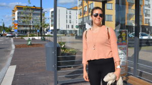 Rosa Hietikko upplever inte att ändringen av bussturerna har påverkat henne. Hon tycker att det går bra att pendla mellan Helsingfors och Sibbo. En kvinna i ljus tröja och solglasögon står vid en busshållplats i Nickby.