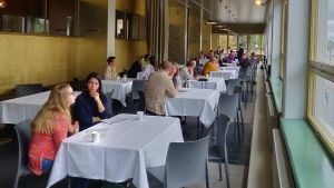 Muse Conversations har ordnats i över 20 olika länder. Rad av bord med vita dukar där deltagare i Muse Conversations sitter parvis och talar med varandra.