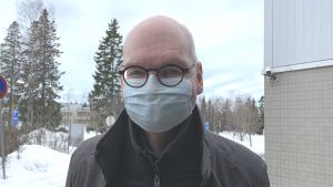 Heikki Kaukoranta, ledande överläkare på Vasa stad, litar på att systemet fungerar och att alla som vill ha ett vaccin också får det. Bland gruppen 80-plussare finns det kvar bara ett hundratal som inte ännu fått sin första vaccindos. Mansperson med munskydd ser in i kameran.