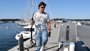 Andreas Öhman är intresserad av tekniken, men anser att den behöver mer tid. Andreas Öhman med en tankingspistol i handen på bryggan i Kasnäs gästhamn i soligt sommarväder.