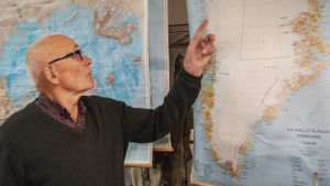 Mies osoittaa sormellaan Grönlannin karttaa