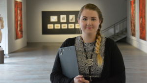Cecilia Gustafsson. En flicka med fläta som jobbar som guide på en konstutställning