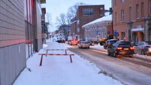 Här är det stopp. En del av trottoaren på Runebergsgatan har stängts av... Två varningsbommar stänger av en del av trottoaren intill Runebergsgatan i Borgå.
