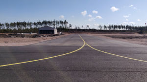 Så här såg flygfältet ut i april 2020. Bild på en landningsbana som förgrenar sig och en byggnad som står intill.