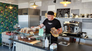 Westerlunds chokladfabrik och butik flyttade till Östermalm i början av året. En man står bakom en disk i ett café och radar upp kex.