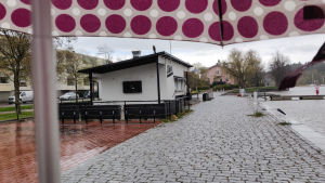 Än så länge håller uteserveringen stängt, och lika så bra är väl det i sådant här väder. En stängd uteservering invid Borgå å. I övre hörnet syns kanten av paraplyt som fotografen står under.