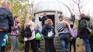 Pasi Nurmi guidar några av de 7 000 besökare som kommer till planetariet varje år. Pasi Nurmi står framför en grupp elever vid ett stjärnobservatorium.