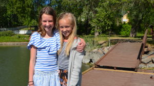 Tilde Engström och Frida Nygård. Två flickor håller om varandra på en brygga.