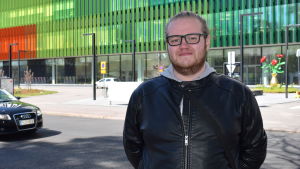 Kim Lindström fick sommarjobb som närdvårdare i sommar. Han tycker inte det var svårt att få jobb inom sin bransch. Kim Lindström står framför Nya barnsjukhuset i Helsingfors.