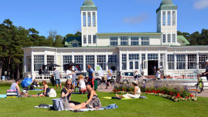 Arrangörerna ordnade inte den här picknicken i Casinoparken i Hangö. Människor sitter framför Hangö Casino och har picknick.