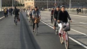 Cykellederna längs stränderna vid Gamla stan är populära. Det Kungliga slottet i bakgrunden. Cyklister på cykelleden intill det Kungliga slottet i Stockholm.