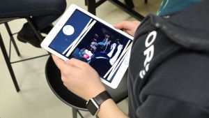 Grafisk design hör till de uppgifter som man kan göra inom e-sporten utan att delta i själva spelandet. Pekplatta där e-sportprogrammets marknadsföringsmaterial syns.