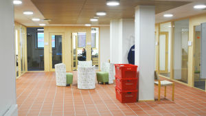 Borgå Elnät flyttade in före Borgå Energi. Några flyttlådor väntar ännu på att packas upp. Aulan i ett kontorsutrymme, några röda flyttlådor.