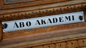 Nordenbrink anser inte att Åbo Akademi behöver ta ställning till eller ställa sig bakom samtliga åsikter som framförs i dess lokaler. Han betonar behovet av att bejaka debatt istället för polarisering. Gammal emaljerad skylt med texten Åbo Akademi, fäst på en dörr i ek.