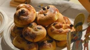 Föräldrar från finska Ilolan koulu var med om att bjuda på bulle. lussekatter på en papperstallrik