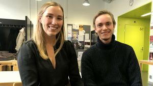 Tim Haglund och Elin Vidlund föredrar speciellt vintertid kvalitetstid med kompisarna än att fara ut på nattklubb. två unga vuxna i svart avslappnad klädsel sitter inomhus i en korridor bland bord, klädhängare och planscher