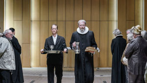 Svend (Joen Højerslev) och Johannes (Lars Mikkelsen) bär ut kyrksilvret då kyrkan stängs och säljs.. Karaktärerna Svend och Johannes omringade av folk.