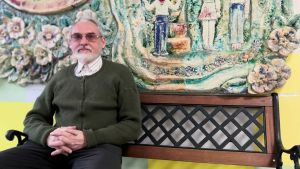 Författaren och lokalhistorikern Jevgenij Balasjov. Jevgenij Balasjov sitter på en bänk med händerna knäppta.