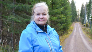 Maj-Louise Wilkman går miste om värdefull skog om kraftledningen byggs över marken. En kvinna vid en skogsväg.