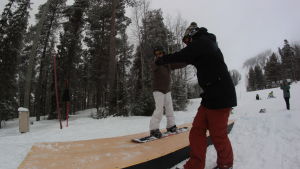 Viktigt med fantasistödjande skidcentrum. Pojke gör snowboardtricks på en dancefloor ramp