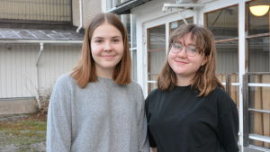 Freja Karlsson och Marielle Lindholm tycker att man i skolan kunde tala ännu mera om drogbrukets konsekvenser i stället för att bara säga till ungdomar att de inte ska använda droger. Freja Karlsson och Marielle Lindholm, två tonåringar står framför dörrar till en skola.