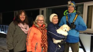 november Synnöve Lindholm, Mirja Koponen, Karin Svahnström med hunden Albert i famnen och idrottsinstruktör Heikki Kiili poserar utanför Solvalla Arenan en vintrig kväll i november.