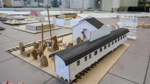Anton och Erik Orander hade en idé om att ställa ut stående restaurangvagnar med parkområden omkring. En miniatyrmodell av en tågvagn på en räls och en byggnad.