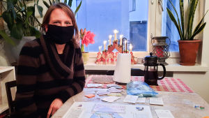 Pihlflyckt spelade ofta brädspel som barn. Som åttaåring ville hon själv bli brädspelsmakare, inspirerad av bland annat Sibbo-vargen. En kvinna i svart munskydd sitter vid ett köksbord. På bordet ligger ett brädspel föreställande Sibbo.