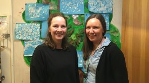 Johanna Muinonen är barnträdgårdslärare och viceföreståndare, och Mia Ahlskog är föreståndare i daghemmet Elka i Helsingfors. Två kvinnor str framför en vägg med dagispyssel.