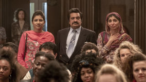 Nä, pappa Malik (Kulvinder Ghir) är först inte alls glad då sonen lyssnar på The Boss och vill skriva lyrik. Pappa Malik (Kulvinder Ghir) omgiven av sin hustru (Meera Ganatra) och dotter (Tara Divina), de står i en sal full människor.