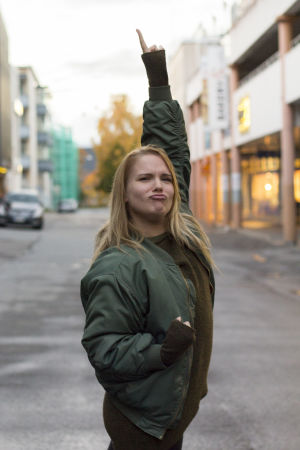 Något bekant med posén? Det är ju en klassisk Freddie Mercury! Sanna Helander poserar som Freddie mercury, med en arm lyft uppåt och fingret pekar mot himlen.