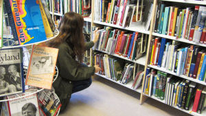 Det gäller att komma ihåg att endast en liten andel av barn och unga beter sig illa på biblioteken. Arkivbild. En kvinna sitter på huk vid en hylla med böcker på ett bibliotek.