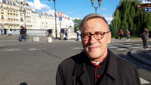Notre-Dames överhuvud prästen Patrick Chauvet tycker inte man ska överdramatisera angående eventuella hälsorisker med blydammet. Patrick Chauvet, iklädd svart prästdräkt med röda detaljer poserar brevid en folktom gata