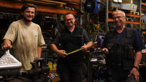 I tre generationer finns tre specialkunnanden, Kevin med svetsande, Micke med plåtslagande och Hasse med smide. Tre män står i en verkstad.