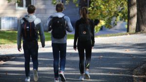 Gillningar och följare kan påverka din popularitet i skolan. Tre ungdomar går på asfalterad väg.