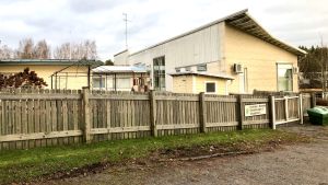 Knattebo eller Muksula på finska har platser för ett- till fyraåringar. Gruppfamiljedaghemmet ligger mitt i kyrkbyn i Pojo, bakom biblioteket och affärerna. Ljusgula byggnader bakom ett trästaket, klätterställningar på gården, ett gruppfamiljedaghem i Pojo. Höst, grönt gräs men inga löv på träden som syns.