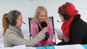 Yle Jyväskylän Radio-kylässä -kierroksella toimittajat Marika Paaso ja ja Heli Kaski haastattelevat 7-vuotiasta Iina Kangasta Konnevedellä kesällä 2013