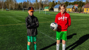 Oliver Sveholm och Robin Gustafsson är taggade på att fotbollsträningarna dras i gång igen. Två pojkar står på en konstgräsplan under en fotbollsträning.