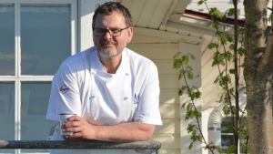 Karl-Erik, Nixu, Knichter vill ha klara besked på hur restauranger ska ordna så smittan inte sprider sig. Arkivbild. En man klädd i vitt står ute med en kaffekopp i handen.