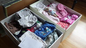 En pojk- och en flicklåda fylld med babykläder. två papplådor fyllda till brädden med babykläder.