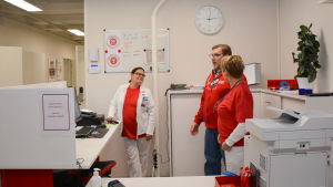 Läkarcentralen har tillräckligt med annan personal, men en läkare skulle behövas. Personalen på en läkarcentral pratar i receptionen.