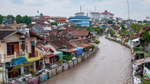 Vaccinet ska ut till varje del av det stora landet. Yogyakarta, Kali Code, Kaupunkinäkymä Yogyakartasta Indonesiassa, etualalla Kali Code-joki.