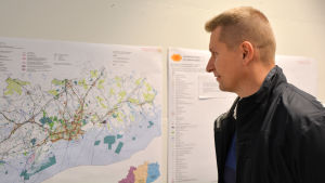 Lappträskbon Anders Mickos bekantar sig med planen. man ser på karta över nylandsplanen
