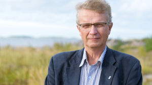Hangö ska testa kalhyggesfritt skogsbruk i sina ekonomiskogar under en tioårsperiod, säger Jukka Takala som basar för tekniska och miljösektorn i Hangö. man i blå kavaj ute vid havet