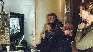 En av de filmer som väntar på premiär är den estnisk-finländska Näkemiin Neuvostoliitto, en dramakomedi om en familj ingermanländare i Tallinn under 1980-och 90-talet. Här en bild från inspelningen med produktionssekreteraren Helis Hirve, sminkör Gristina Krüger och regissören Lauri Randla. Inspelning av filmen Näkemiin Neuvostoliitto, regissören Randla sitter i ett rum och följer på en monitor inspelningen tillsammans med några andra människor.