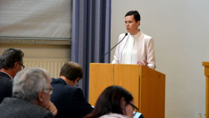 Maarit Feldt-Ranta välkomnar öppen diskussion om feminism men tycker inte att politiker måste deklarera sig som feminister. Frågan finns inbakad i Socialdemokraternas ideologi och det räcker, säger hon. Maarit Feldt-Ranta står i en talarstol.
