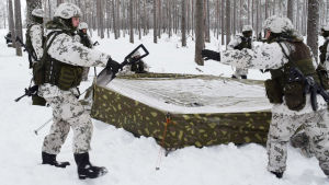 Att slå läger i djup snö är lite annorlunda än att göra det på torr mark. Beväringar sätter upp ett militärtält där de ska övernatta i Galoppskolgen i Baggby, Raseborg.