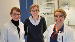 Jaana Koskenniemi, Laura Viikari och Tarja Eronen hälsar alla 75-åringar välkomna till 75-årsrådgivningen. Tre damer, Jaana Koskenniemi, Laura Viikari och Tarja Eronen, står vid en öppen sjukhusdörr.