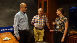Projektets Jennifer Holmberg svarar på frågor om avloppsvatten tillsammans med Tapani Henkola och Urho Ilmonen. två män och en kvinna som står och diskuterar i ett mötesrum
